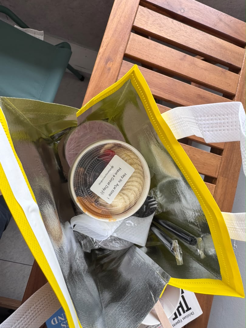 Açaí bowl order packed with utensils inside an open yellow insulated bag