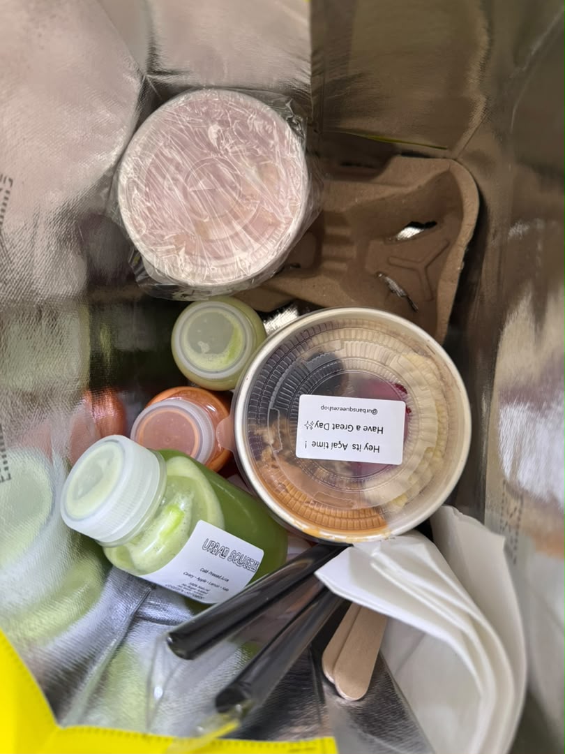 Açaí bowls, green and orange juices, and utensils packed inside an insulated bag